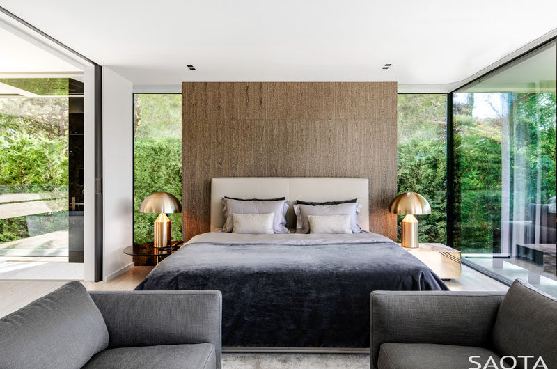 Bedroom Ideas - This modern bedroom has been designed with floor-to-ceiling glass walls and a wood accent wall. #GlassWalls #ModernBedroom #BedroomIdeas