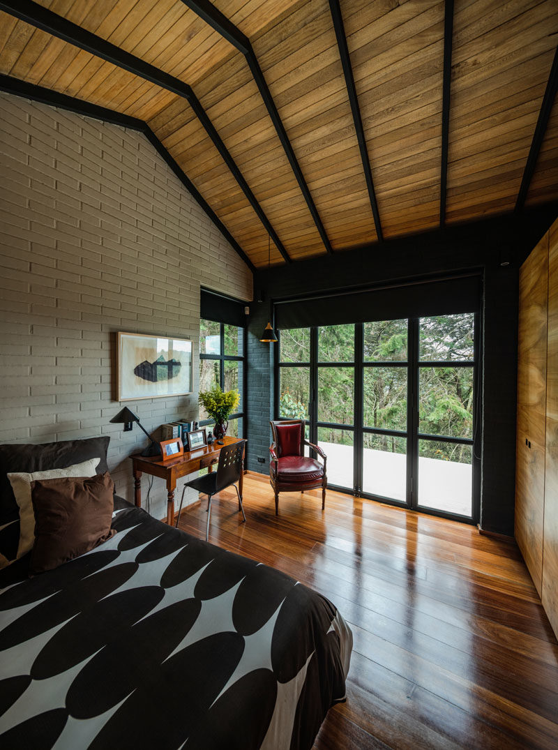 Bedroom Ideas - This modern bedroom has high ceilings and black-framed glass doors that open to a private patio. #Bedroom #ModernBedroom #GlassDoors #WoodCeiling #HighCeiling