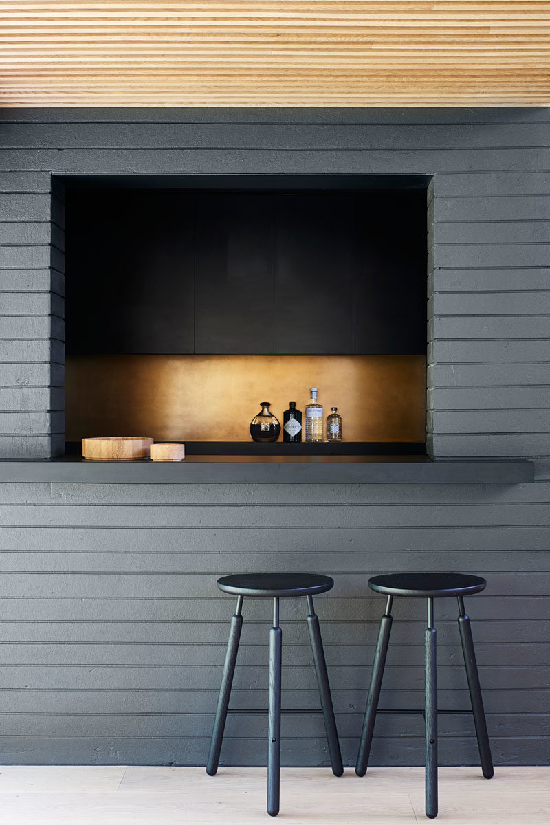 Home Bar Ideas - This modern black home bar features a metallic accent, creating a luxurious feeling. #HomeBar #ModernBar #BarDesign 