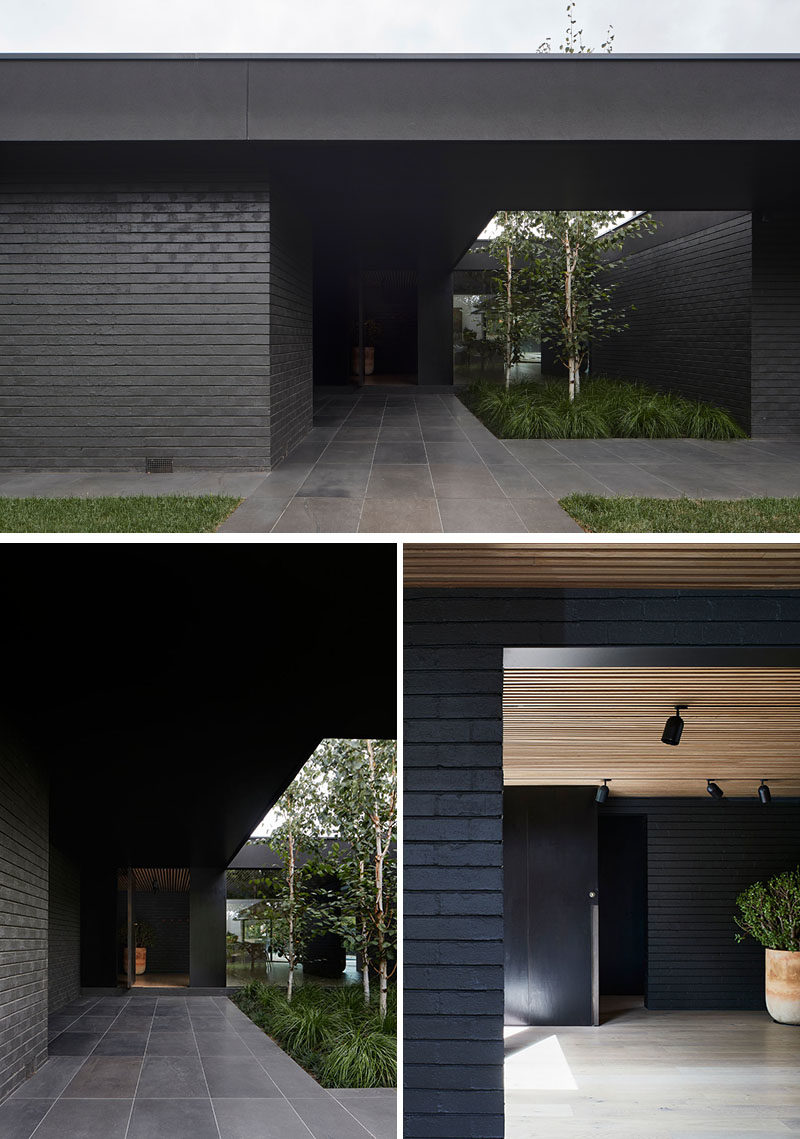 On arrival to this modern black house, the entry is defined by an oversized eave that's been punctured to allow soft landscaping adjacent the entrance, as well as provide increased light into the interior of the home. #ModernHouse #BlackHouse #HouseDesign #Landscaping