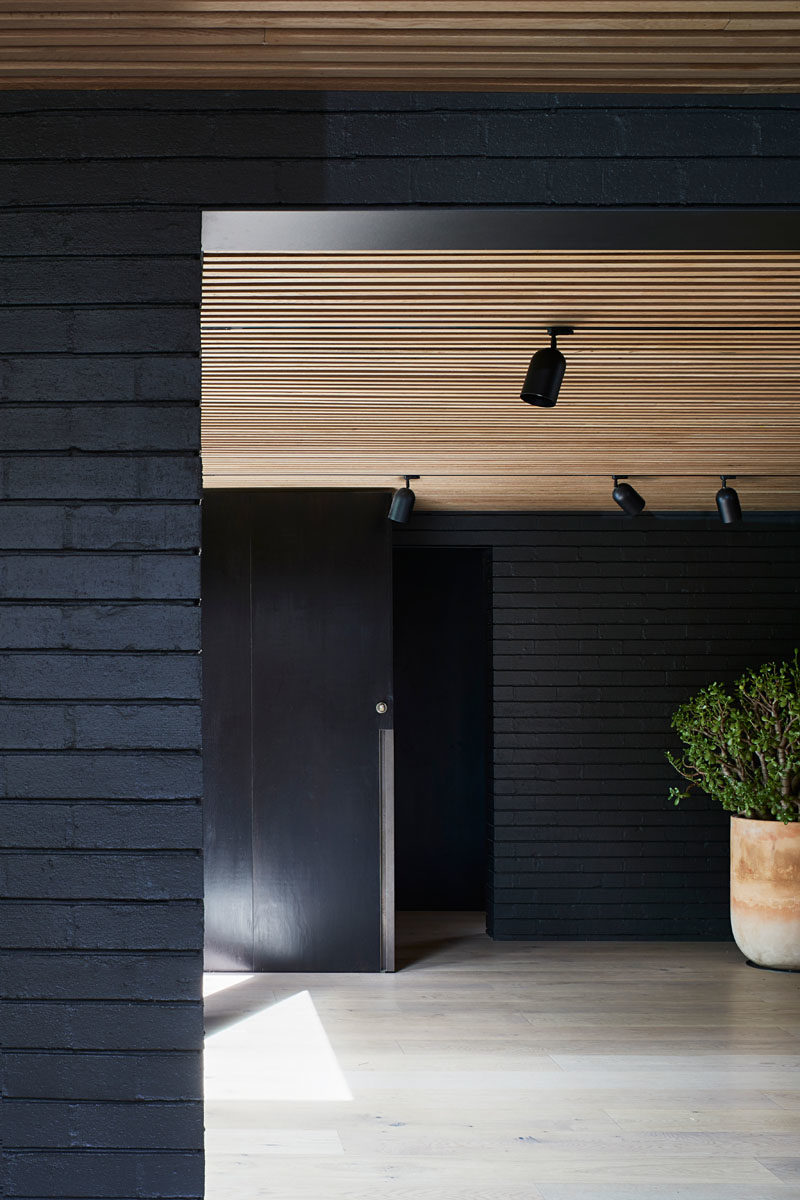 The exterior materials, like black brick, have been carried through to the inside of this house, creating a cohesive look and modern interior. #ModernInteriorDesign #ModernArchitecture #BlackBrick