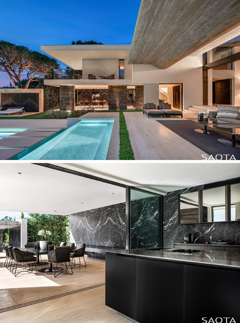 This modern house has terraces can also be accessed via the dining room and kitchen, that are both stepped down from the foyer, and feature dark marble walls. #Terraces #ModernHouse #DiningRoom #Kitchen