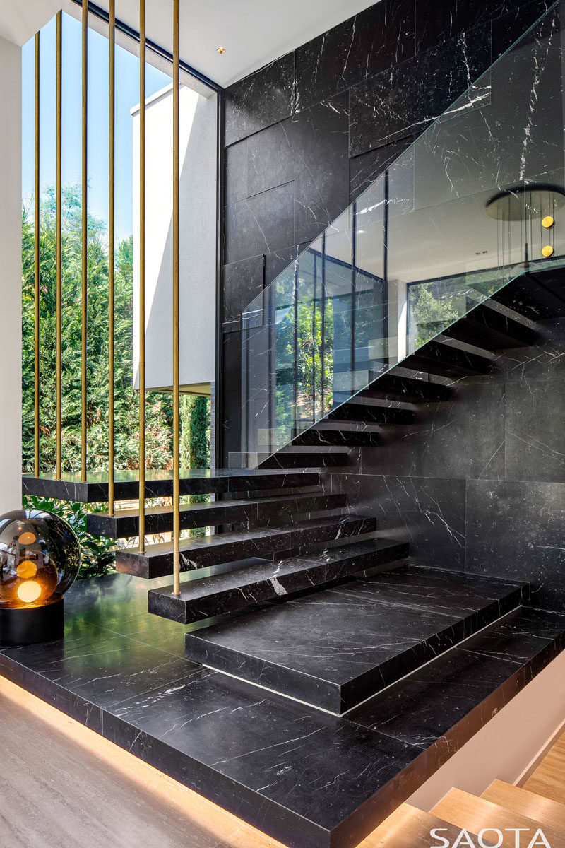 Stair Ideas - This modern house has marble stairs with a glass handrail, that travel past a large floor-to-ceiling window. #Stairs #Marble #ModernStairs