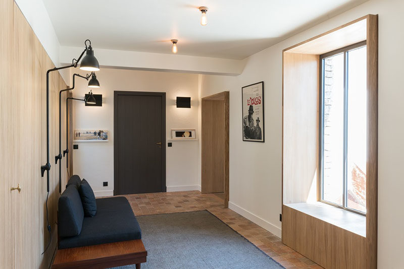 Window Seat Ideas - This modern hallway has a partially built-in window seat, that's lined with wood and views of the garden outside. #WindowSeat #WindowSeatIdeas #Seating