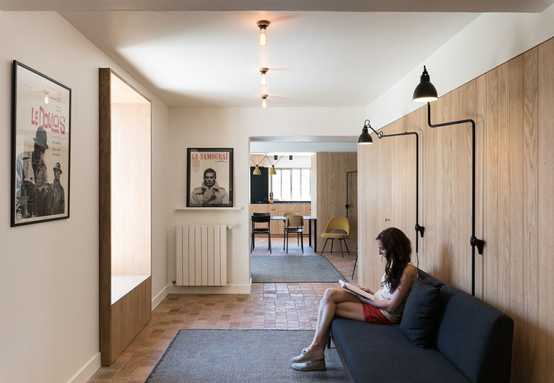 Window Seat Ideas - This modern hallway has a partially built-in window seat, that's lined with wood and views of the garden outside. #WindowSeat #WindowSeatIdeas #Seating