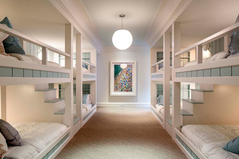 Bedroom Ideas - In this modern and large bedroom, multiple bunk beds have been built into the room, with stairs allowing easy access to the upper bunks. #BunkBeds #BedroomIdeas #GuestRoom