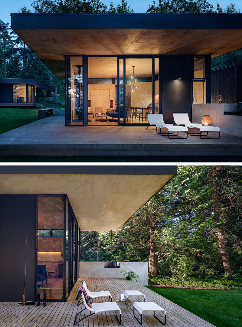 The design of this modern cabin include an indoor outdoor kitchen that has a pass-through window that extends the interior countertop into the outdoor concrete counter and built in wood barbeque. #ModernCabin #KitchenDesign #OutdoorKitchen #BBQ