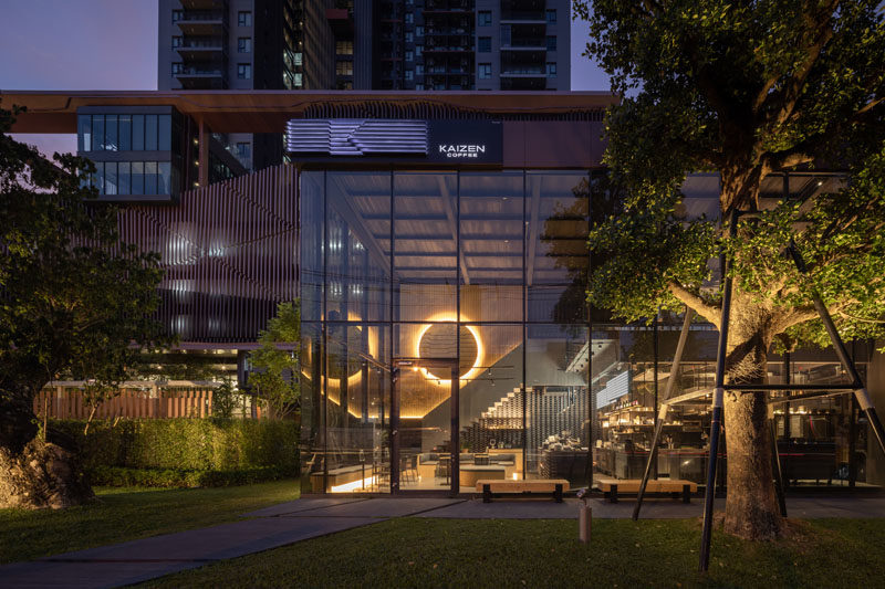 Inside this modern coffee shop, the high ceilings are immediately apparent, while wood and grey elements have been used to create a cozy atmosphere. #CoffeeShop #CafeDesign #RetailDesign #InteriorDesign