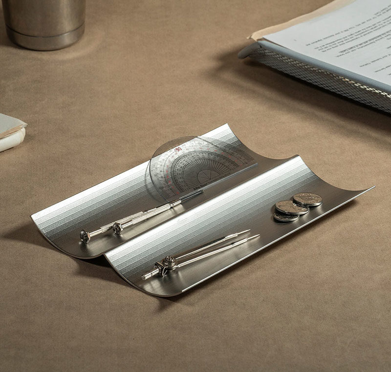 Gift Ideas - This modern tray is made from a single piece stainless steel, and has a wavy shape, creating a catch-all for pens, paperclips, and business cards. #ModernTray #HomeOfficeDecor #HomeOfficeAccessories #GiftIdeas #Design