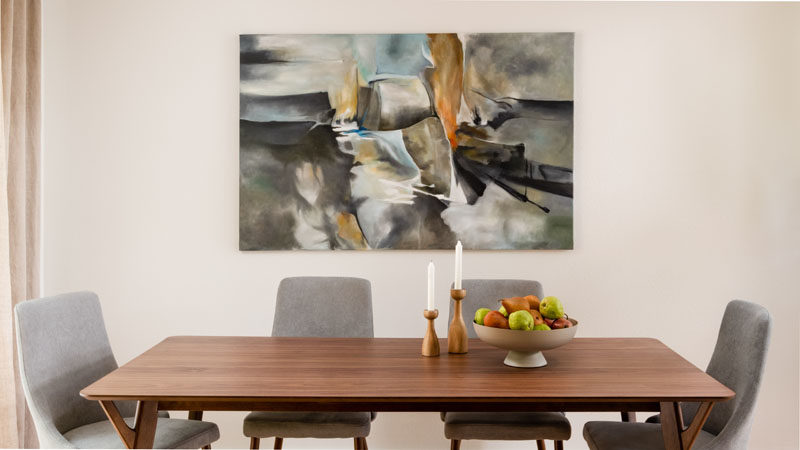 Dining Room Ideas - This modern dining room features a modern wood table and light grey chairs, that are complemented by a bespoke art piece on the wall. #DiningRoomIdeas #ModernDiningRoom #DiningRoomDesign