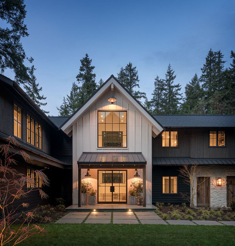 The exterior of this modern farmhouse features tight knot cedar tongue and groove siding finished in a black stain, and an accent of white board and batten siding. #ModernFarmhouse #FarmhouseMOdern #Siding