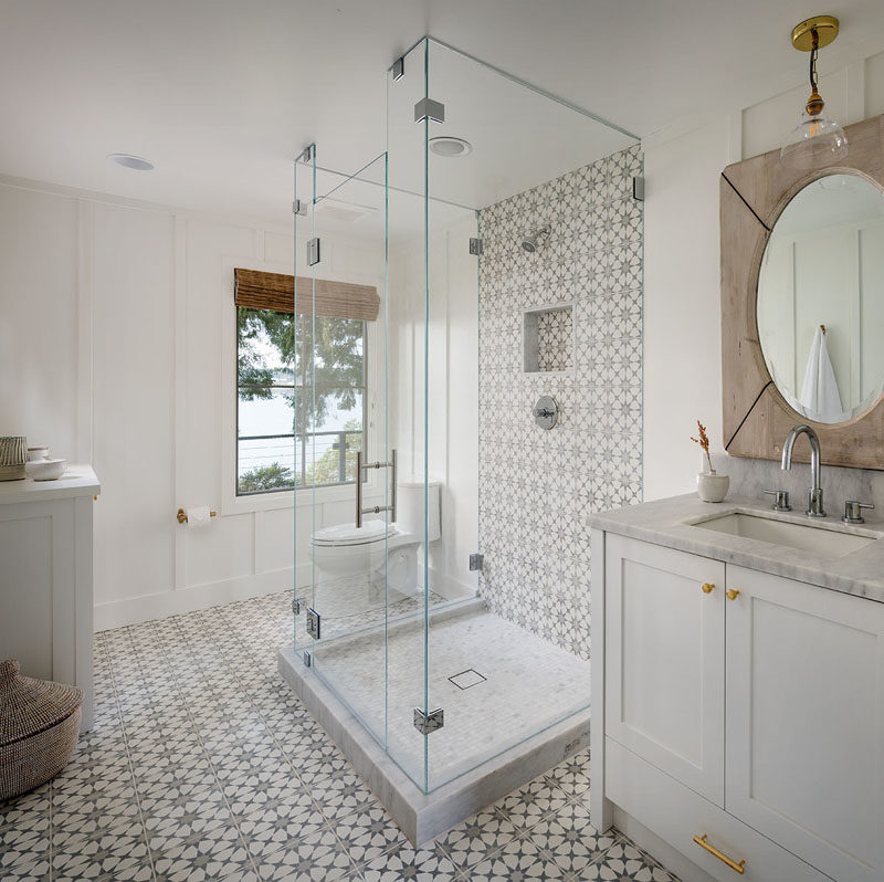 Bathroom Ideas - This modern bathroom has a glass-enclosed walk-in shower. By having a glass shower surround, it allows the natural light from the window to fill the room. #ModernBathroom #BathroomIdeas #GlassEnclosedShower #ShowerIdeas