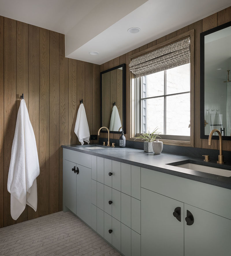 Bathroom Ideas - In this modern bathroom, the walls have been lined with wood and accented by black detailing, like the mirror frames, wall hooks, and cabinet hardware. #BathroomDesign #ModernBathroom