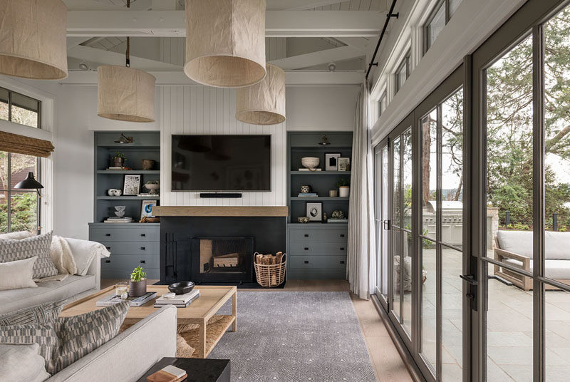 Living Room Ideas - This farmhouse modern living room has a fireplace with a television mounted above it, and built-in cabinetry on either side. #LivingRoomIdeas #ModernLivingROom #FarmhouseModern