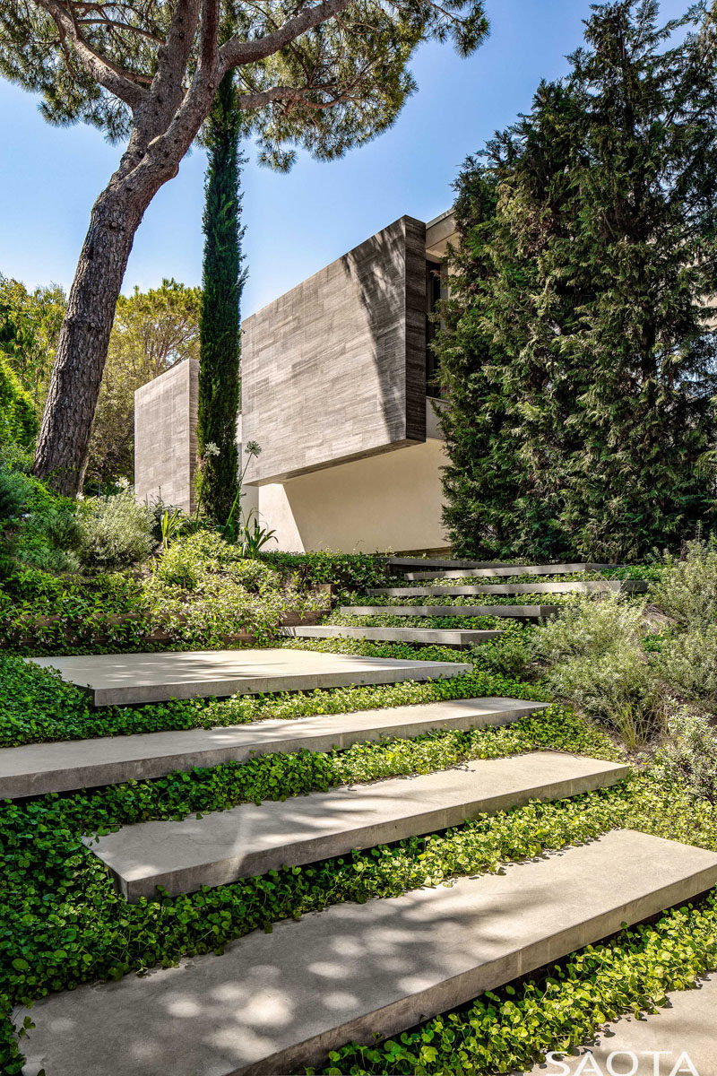 Landscaping Ideas - Welcoming visitors to this modern house is an entrance path with concrete steps that lead from the off-street parking below the house, through the garden, and to the front door. #Landscaping #ModernHouse #GardenSteps #ConcreteSteps