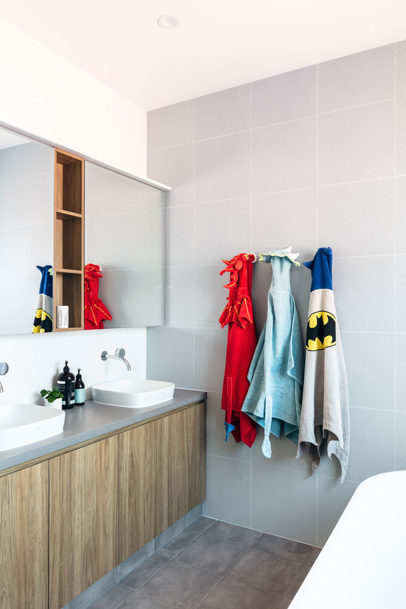 Bathroom Ideas - This modern bathroom features large grey square tiles that cover an entire wall. #BathroomIdeas #ModernBathroom