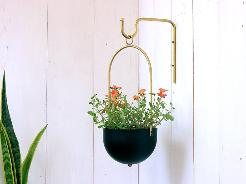Decor Ideas - Tel Aviv based designer Yuval Tzur has created a modern hanging planter with a simple curved shape, and a matching brass wall hanger.  The planters are made from hand spun aluminum, that are then powder coated to create a durable finish suitable for both indoor and outdoor use. #HomeDecor #Planter #HangingPlanter #ModernPlanter #DecorIdeas