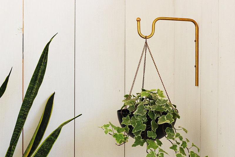 Decor Ideas - Tel Aviv based designer Yuval Tzur has created a modern hanging planter with a simple curved shape, and a matching brass wall hanger.  The planters are made from hand spun aluminum, that are then powder coated to create a durable finish suitable for both indoor and outdoor use. #HomeDecor #Planter #HangingPlanter #ModernPlanter #DecorIdeas