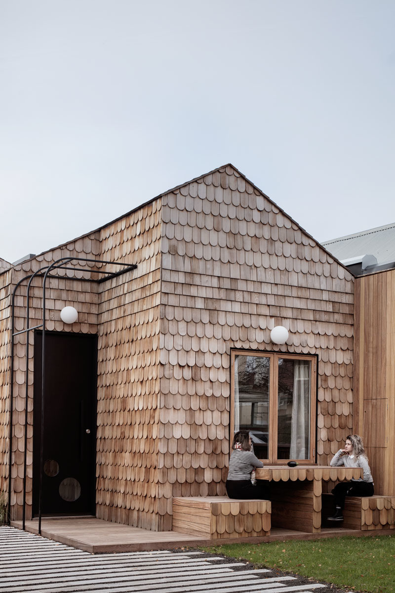 Mani Architecture has designed a modern cottage-like house in Melbourne, Australia, that's covered in wood shingles and features a built-in table and chairs in the front garden. #Shingles #ModernHouse #HouseDesign #Architecture