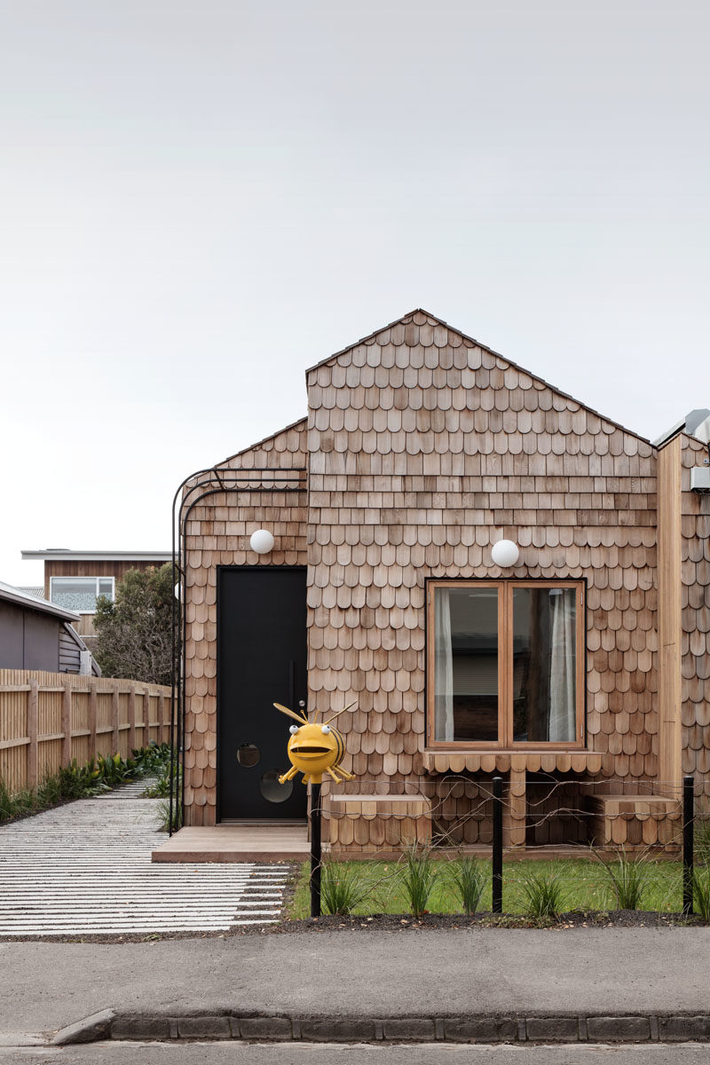 Mani Architecture has designed a modern cottage-like house in Melbourne, Australia, that's covered in wood shingles and features a built-in table and chairs in the front garden. #Shingles #ModernHouse #HouseDesign #Architecture