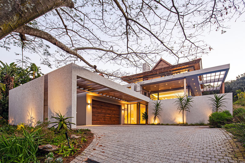 Drawing inspiration from tropical modern architecture, this house was designed to have an elemental roof form with large eaves, an overhanging upper storey, and indoor/outdoor living. #ModernHouse #HouseDesign #ModernArchitecture #TropicalModern