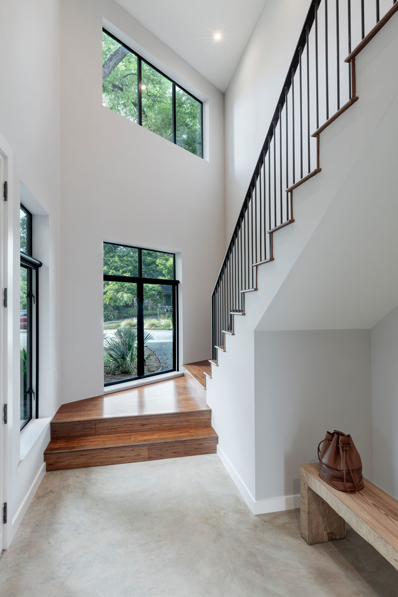 Stair Ideas - Wood stairs with black handrails connect the various levels of the home. #ModernStairs #StairDesign #StairIdeas