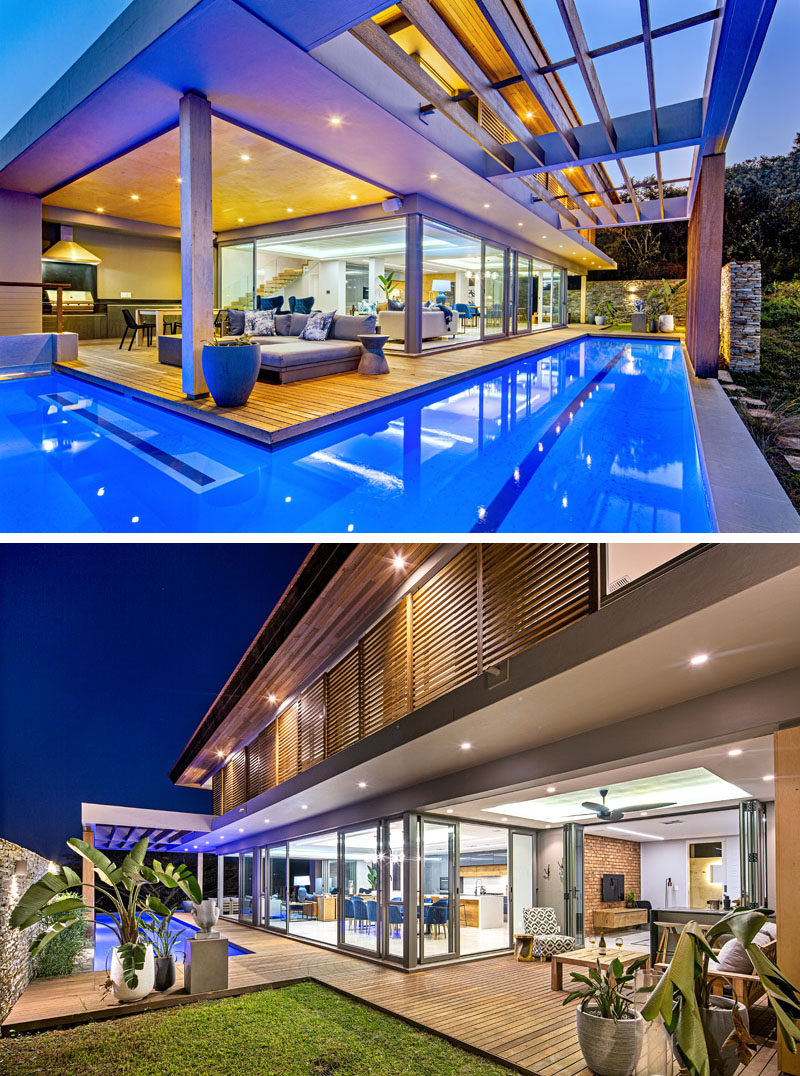 Swimming Pool Ideas - This modern house has glass walls that open to a a lap pool that wraps around the social areas of the home. #SwimmingPoolIdeas #PoolIdeas #SwimmingPool #LapPool #Architecture
