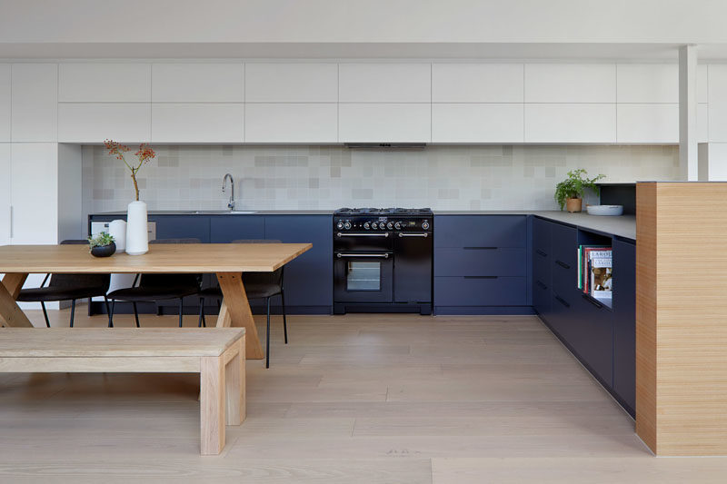 Kitchen Ideas - In this modern two-tone kitchen, dark blue cabinets have been used for the lowers, while minimalist white cabinets create additional storage and blend into the white walls. #ModernKitchen #KitchenDesign #KitchenIdeas