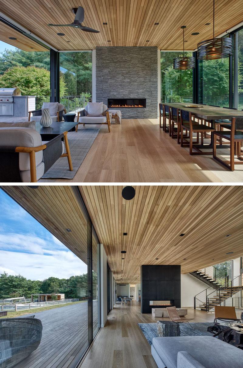 Living Room Ideas - Inside this modern house, the main social areas, like the living room and dining room all share the same open room. Two fireplaces, one at each end of the room, and wood ceiling and flooring, add warmth to the space. #LivingRoom #DiningRoom #LivingRoomIdeas #InteriorDesign #WoodCeiling
