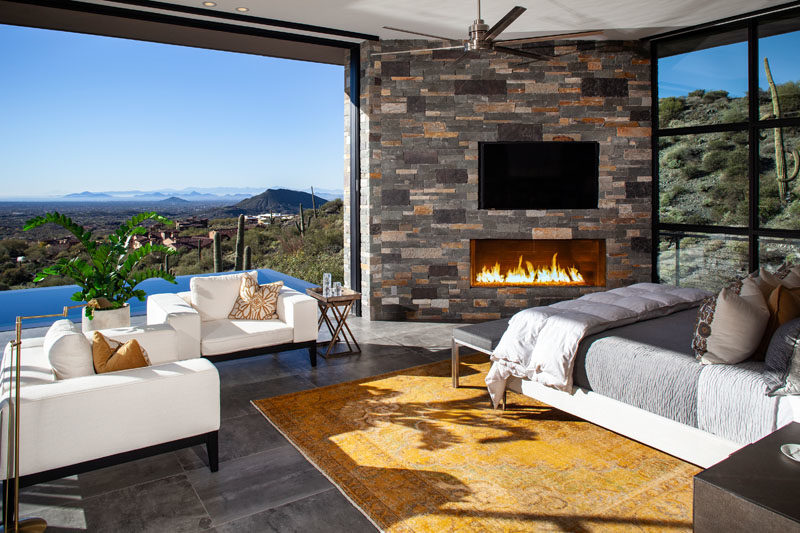 Bathroom Ideas - This modern master bedroom has sweeping views of the valley, a sitting area, and a fireplace in the corner adding warmth on cool nights. #BedroomIdeas #MasterBedroom #Fireplace