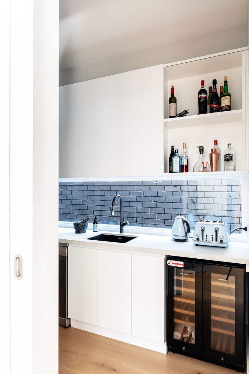 Pantry Ideas - This modern kitchen pantry has plenty of storage, a sink, counter space, and a bar area. #KitchenPantry #PantryIdeas