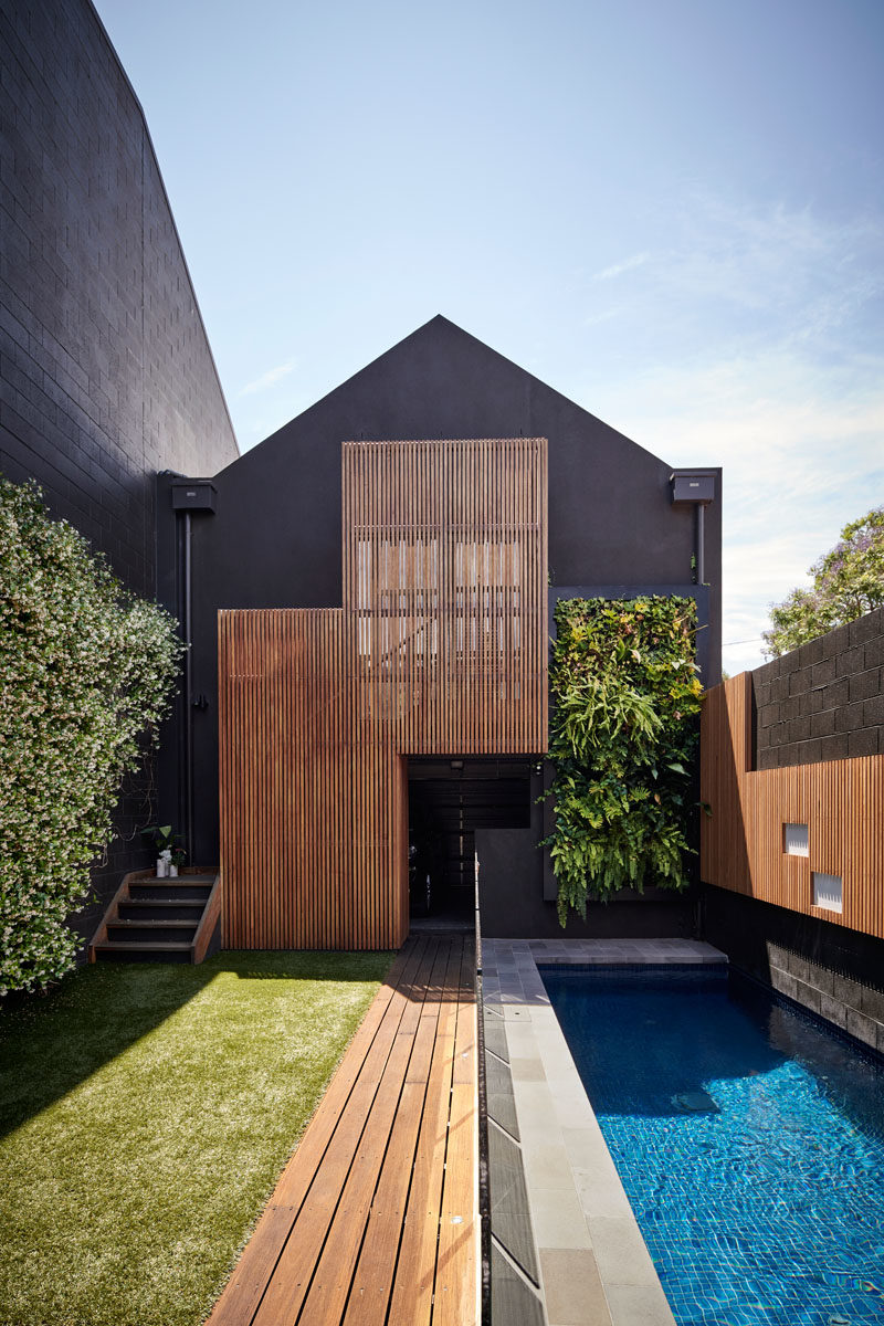 Swimming Pool Ideas - Feature light panels in the accent wall reflect the timber cabinetry within the house, with some of the light panels in the wall exposed, while others are partially hidden behind timber battens, creating a playful element to the space and reflecting on the pool water in the evening. #SwimmingPoolIdeas #PoolIdeas #GardenIdeas #LnadscapingIdeas #ModernPool