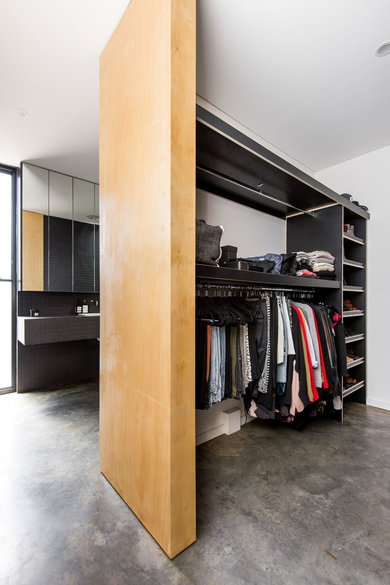 This master bedroom suite has an open walk-in wardrobe that features custom shelving. #WalkInCloset #ClosetDesign