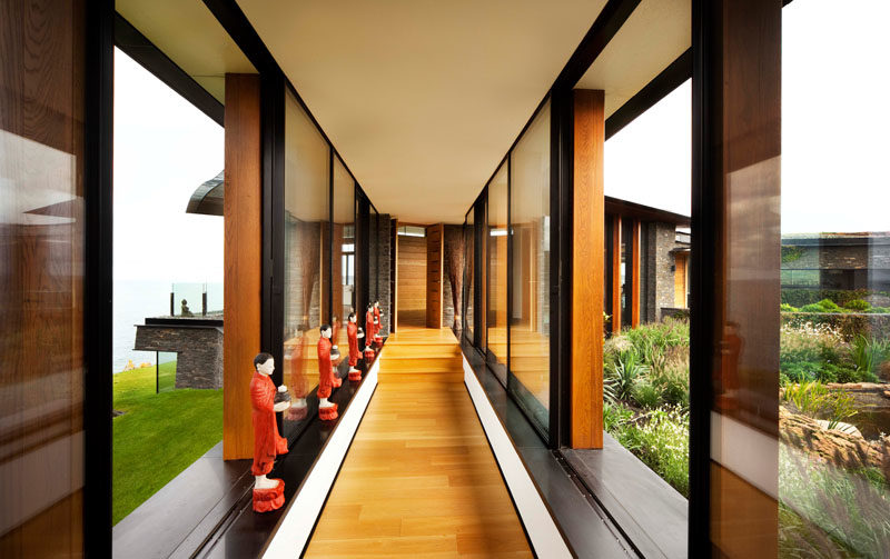 Hallway Ideas - A window-lined hallway connects the various areas of this modern house, and showcases the wood flooring, and the views on either side. #Hallway #Windows