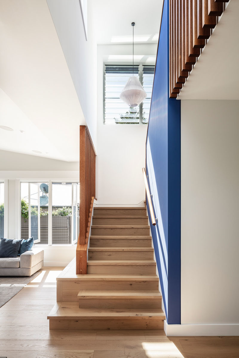 Stair Ideas - This updated house has a blue accent wall that follows the wood stairs. #BlueAccentWall #WoodStairs