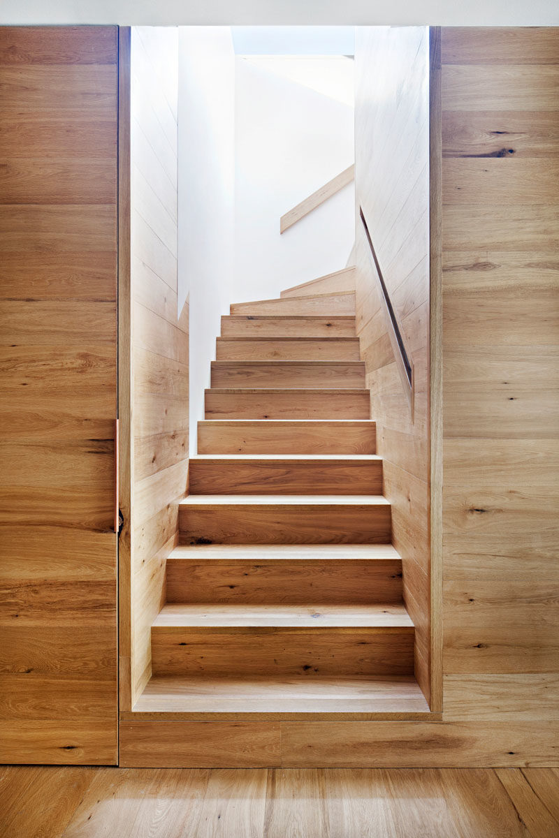 Stair Ideas - This modern house has oak wood stairs with a built-in handrail that lead to the upper floor of the home. #Stairs #WoodStairs #ModernHouse