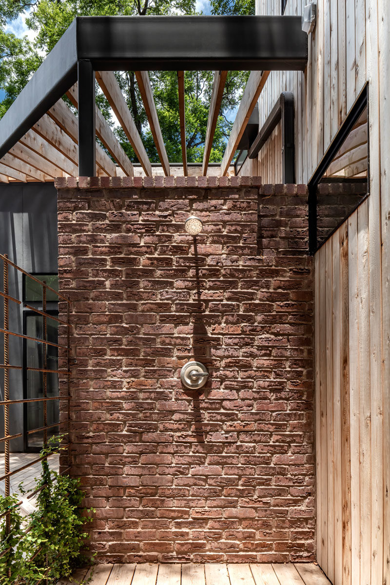 Bathroom Ideas - This modern house has an outdoor shower attached to a brick wall, that's tucked away in the backyard. #OutdoorShower #BathroomIdeas 