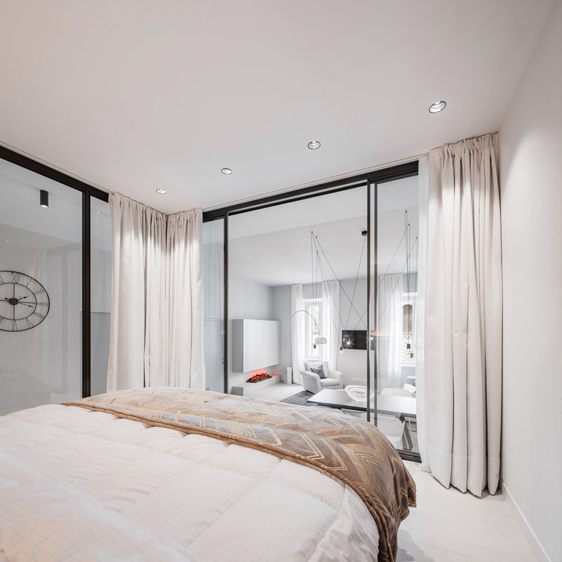 Small Apartment Ideas - This modern small apartment has a raised glass-enclosed bedroom that's able to enjoy the natural light that filters through from the windows in the living room. #SmallApartmentIdeas #SmallApartment #GlassEnclosedBedroom #GlassWalls