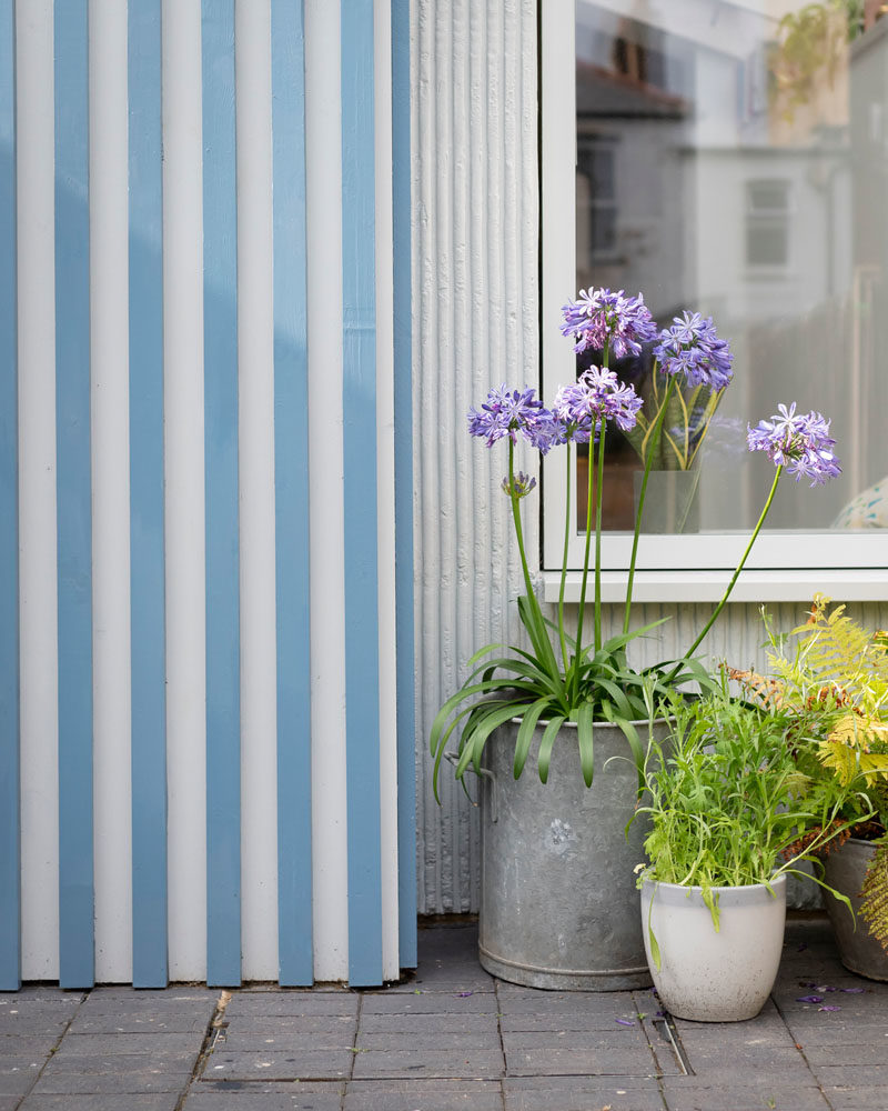 Facade Ideas - This modern house extension features a bright blue and white striped facade. #Facade #StripedFacade #ModernArchitecture