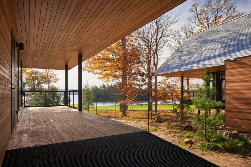 This collection of modern cabins are clad in shiplapped wood, which adjoins a glass pavilion that holds an open-plan living and dining space. They also have a deep hip roof that's clad with cedar shingles. #ModernCabin #Architecture #CabinDesign