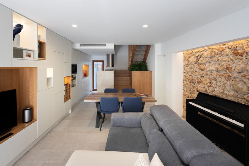 This narrow house made it important to use the space efficiently, and instead of having an empty space at the bottom of the stairs, they included a cabinet made from the same wood as the stairs, that's large enough to provide storage for a bike. #BikeStorage #HdidenStorage #InteriorDesign #StairDesign