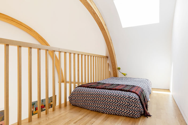 Bedroom Ideas - This modern loft receives natural light from a skylight, while curved wood beams show off the shape of the ceiling. #LoftBedroom #CurvedCeiling #Skylight