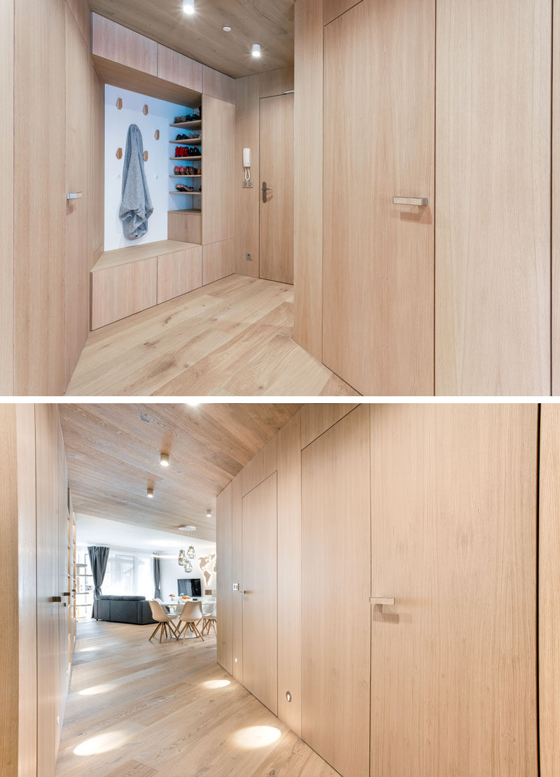 Entryway Ideas - In the entryway of this modern apartment, a custom nook has wall hooks, open shelving, and a cabinet that doubles as a bench. #EntrywayIdeas #InteriorDesignIdeas #ApartmentIdeas #