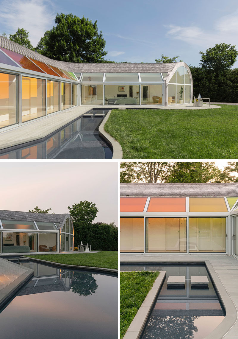 The colors of the skylights above the hallway of this modern house also appear in the reflecting pool that runs alongside the home. #Skylights #Windows #Landscaping #ReflectingPool