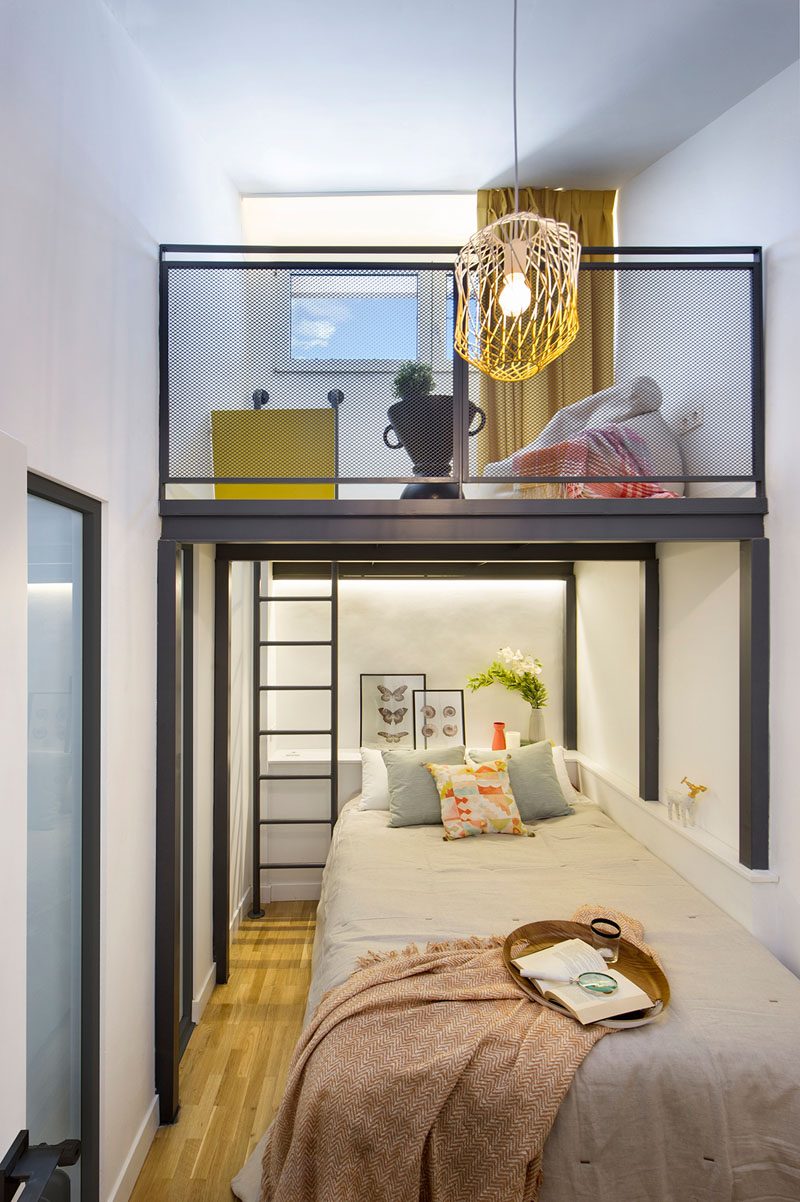 This modern and small bedroom has a loft that's accessed via a small black ladder. #SmallBedroom #BedroomLoft #BedroomDesign