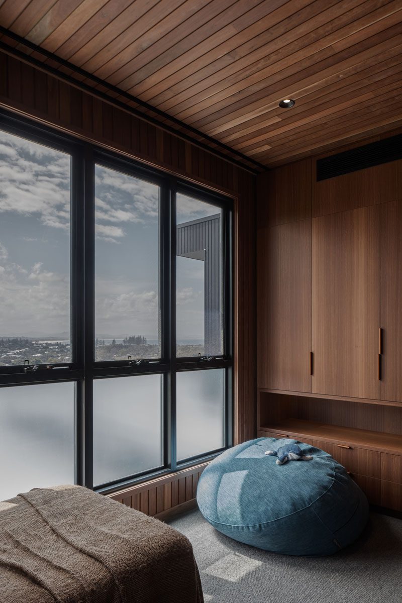 The lower windows in this wood-lined bedroom are opaque to allow for privacy from the neighborhood. #OpaqueWindows #PrivacyWindows #WindowIdeas #WoodBedroom