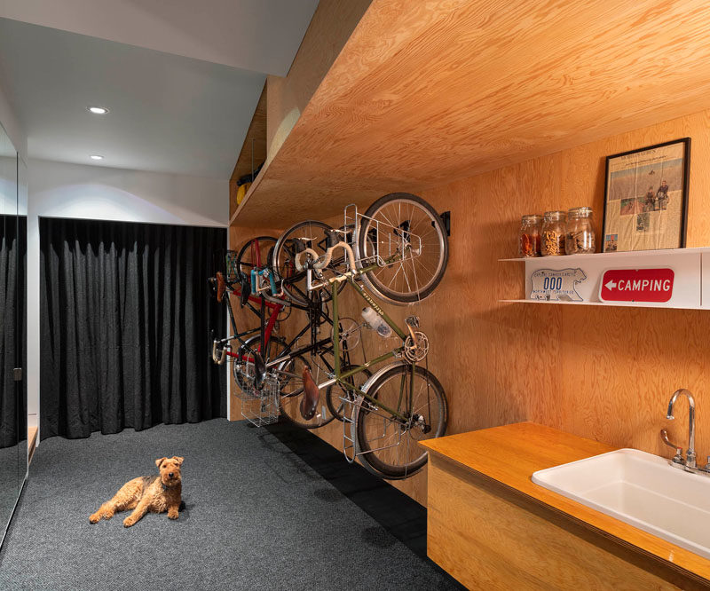 This spacious bike storage room includes 10 feet of closet space, wall storage for 8 bicycles, and a generous clean-up area with a sink. Once boots and coats have been put away, a second interior stair ascends to the ground floor living space. #BikeStorage #BikeStorageRoom