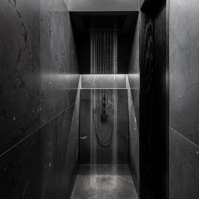 Bathroom Ideas - In this modern black bathroom, a rainfall shower head makes a statement in the small space. #BathroomIdeas #ShowerIdeas #BlackBathroom #ModernBathroom