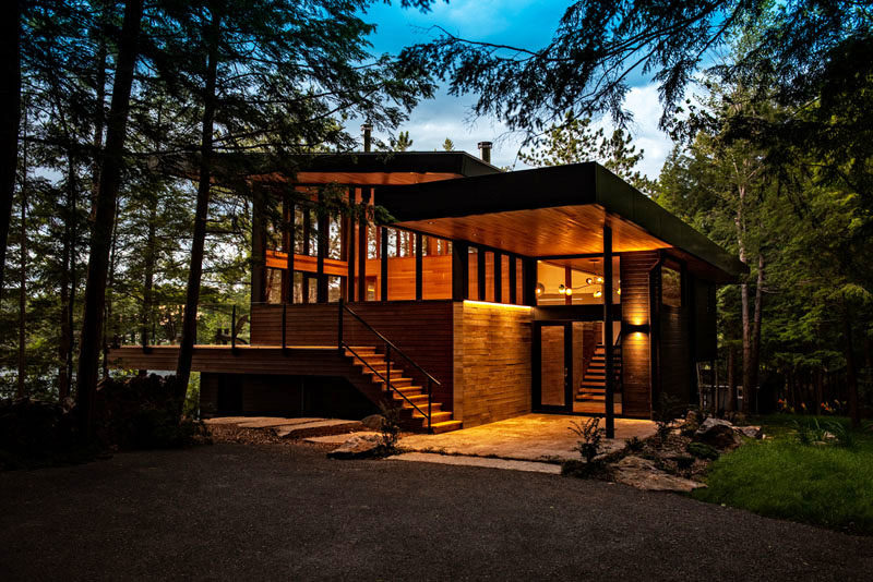 a new wood, concrete, and glass house faces a canadian lake