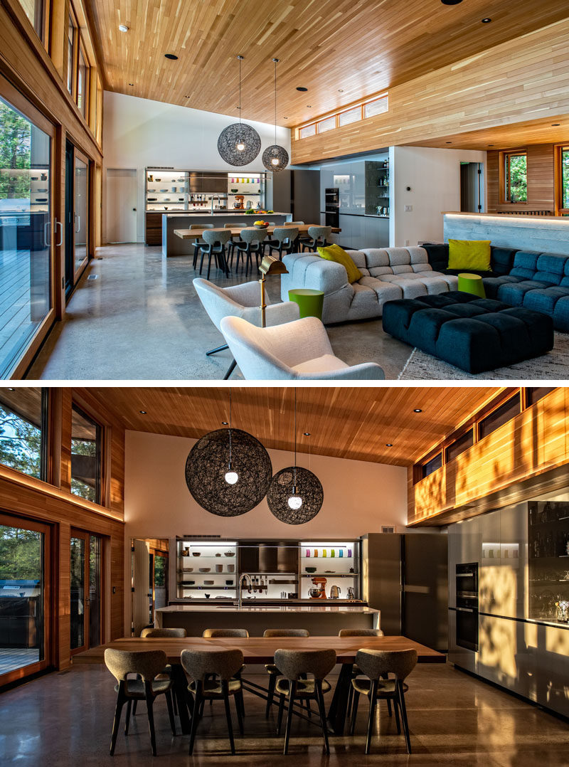 Dining Room Ideas - The dining area of this modern cottage separates the living room from the kitchen, with the large dining table making it easy to host family diners. The dining table has also been positioned in a way that no one has their back to the view. #DiningRoom #ModernCottage #WoodCeiling